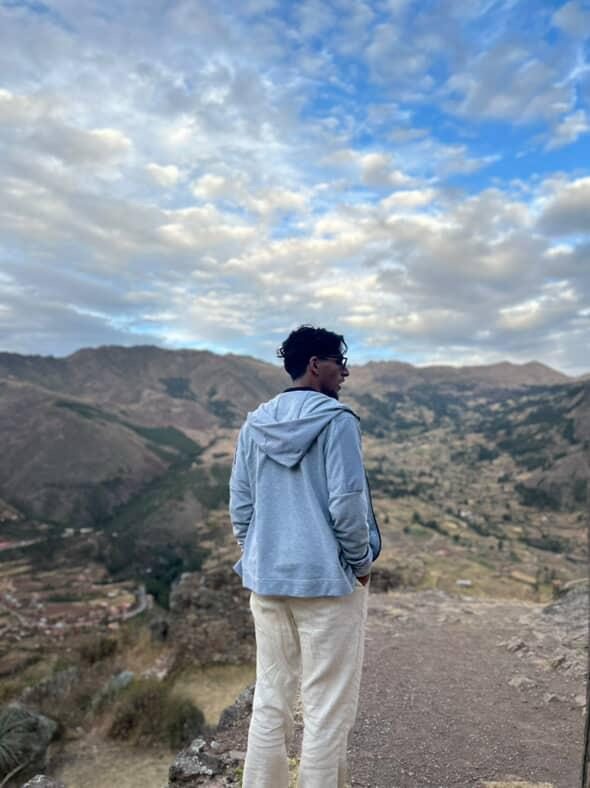 Standing on a ridge looking out over a wide Andean valley under a big sky.